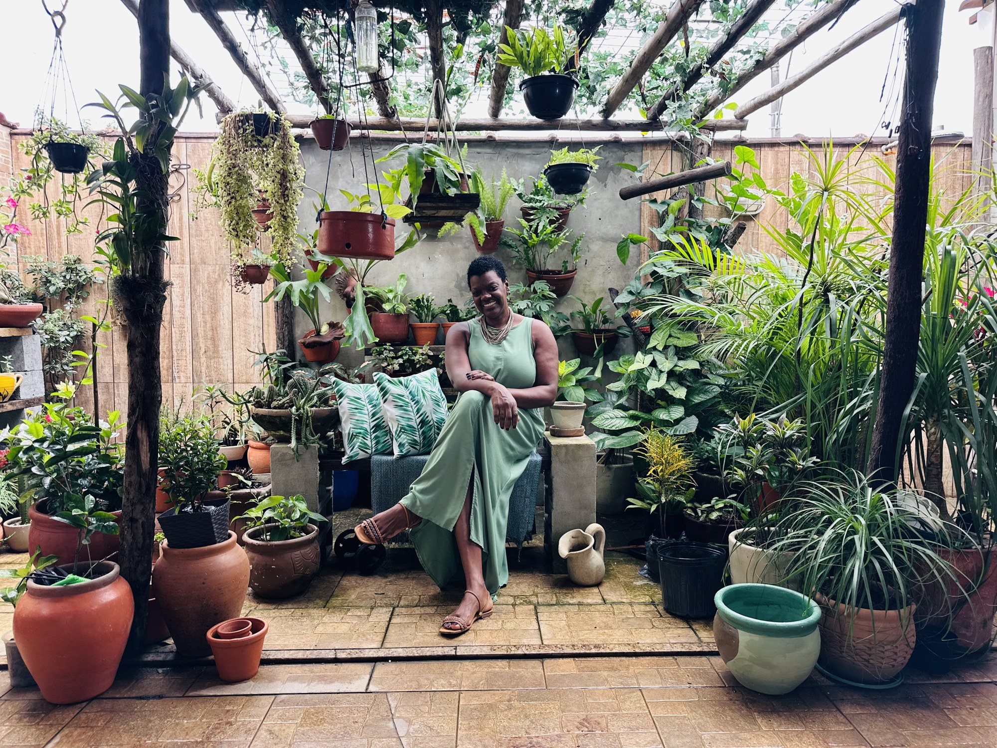 Mulher cercada por plantas em um jardim verdejante